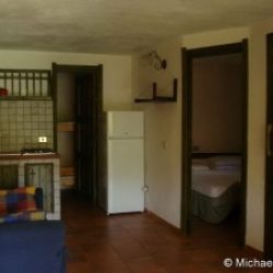 Wohnzimmer mit Couch und Küchenzeile des Ferienhauses India an der Costa Rei, Sardinien