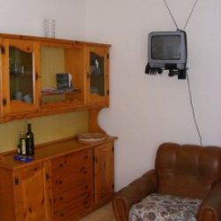 Wohnzimmer mit Anrichte und Sessel in den Ferienhäusern Pisu an der Costa Rei, Sardinien