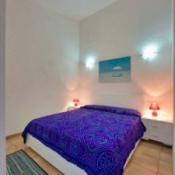 Schlafzimmer mit Doppelbett in den Ferienhäusern Turagri an der Costa Rei, Sardinien