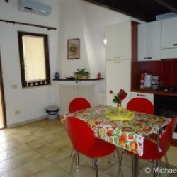 Wohn- und Essbereich mit Küchenzeile und offenem Kamin in den Ferienhäusern Turagri an der Costa Rei, Sardinien