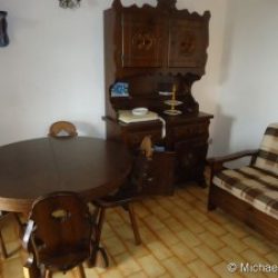 Wohnzimmerm mit Anrichte, Sitzgruppe und Sessel in der Ferienwohnung Ginestre Basse an der Costa Rei, Sardinien