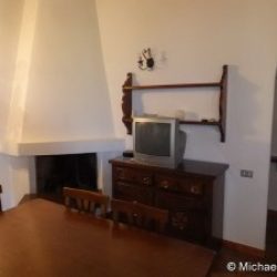 Wohnzimmer mit Esstisch und offenem Kamin der Ferienwohnungen Ginster an der Costa Rei, Sardinien