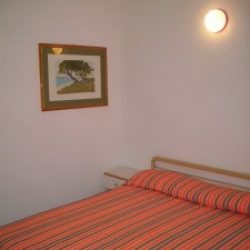 Schlafzimmer mit Doppelbett in der Ferienwohnung Mimose an der Costa Rei, Sardinien