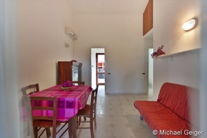 Wohn- und Esszimmer mit Doppelcouch und Essbereich des Ferienhauses Marina Trilo an der Costa Rei, Sardinien