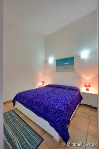 Schlafzimmer mit Doppelbett in den Ferienhäusern Turagri an der Costa Rei, Sardinien