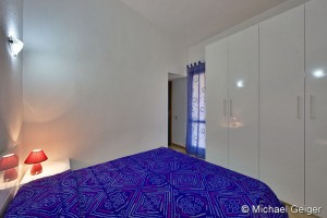 Schlafzimmer mit Doppelbett und großem Kleiderschrank in den Ferienhäusern Turagri an der Costa Rei, Sardinien