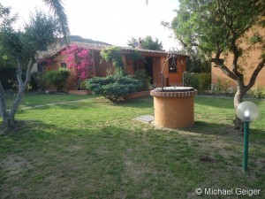 Garten mit Brunnen und Zugang zur Ferienvilla Ginestre an der Costa Rei, Sardinien