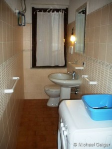 Badezimmer mit Waschbecken, WC und Waschmaschine der Ferienvilla Ginster an der Costa Rei, Sardinien