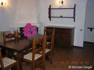 Wohnzimmer mit offenem Kamin und Sitzgruppe in der Ferienvilla Ginster an der Costa Rei, Sardinien