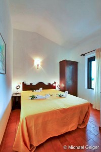 Doppelbett und Kleiderschrank im Schlafzimmer der Ferienvilla Lentischio an der Costa Rei, Sardinien