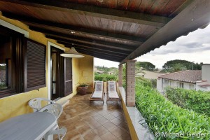 Geflieste, überdachte Terrasse mit Sonnenliegen der Ferienvilla Lentischio an der Costa Rei, Sardinien