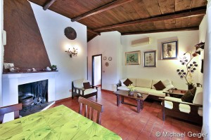 Wohnzimmer mit offenem Kamin und Sitzgruppe der Ferienvilla Lentischio an der Costa Rei, Sardinien