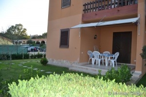 Gepflegter Garten und Terrasse mit Sonnenrollo der Ferienwohnung Gianfranco an der Costa Rei, Sardinien