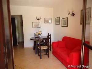 Wohnzimmer mit Doppelcouch und Sitzgruppe in der Ferienwohnung Ginestre Basse an der Costa Rei, Sardinien