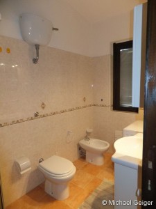 Badezimmer mit Waschmaschine, Waschbecken, WC und Bidet in der Ferienwohnung Ginster an der Costa Rei, Sardinien
