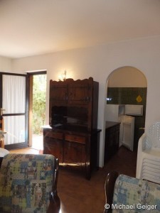 Wohnzimmer mit Anrichte und Blick in die Küche der Ferienwohnungen Ginster an der Costa Rei, Sardinien