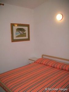 Schlafzimmer mit Doppelbett in der Ferienwohnung Mimose an der Costa Rei, Sardinien