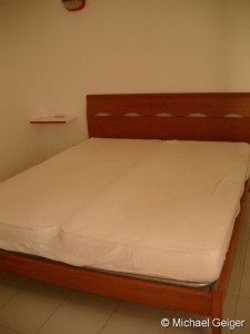 Doppelbett im Schlafzimmer in der Ferienwohnung Mimose an der Costa Rei, Sardinien